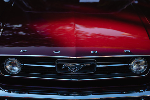 Front grille and red hood of a classic restored Ford Mustang