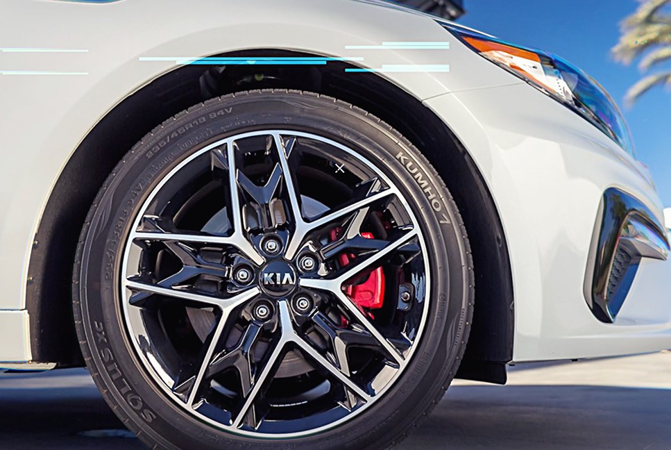 Close-up of a performance wheel, brake caliper and white bodywork